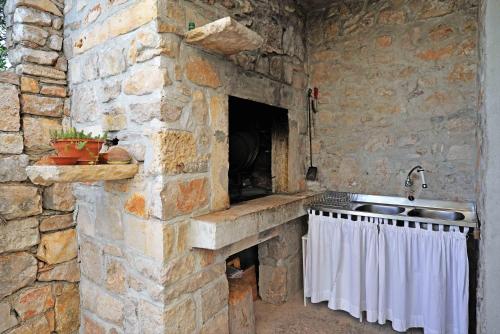 cocina de piedra con fregadero y pared de piedra en Apartment Stari Murter, en Murter