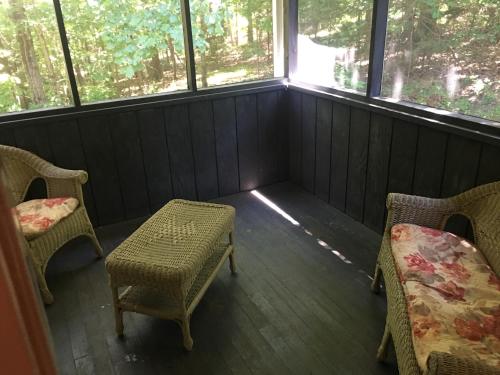 a room with two chairs and a table and two windows at Echo Valley Cottages in Coolbaugh
