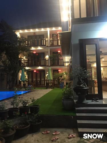 a hotel with a lawn in front of a building at Village Moon Villa in Hoi An
