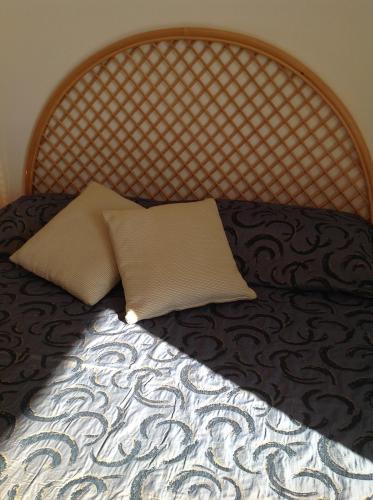 a bed with a wooden headboard with a pillow on it at Hotel Miramare Garzia in Marinella di Selinunte