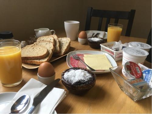 a wooden table with eggs bread and other food on it at Dynjandi Guesthouse in Höfn