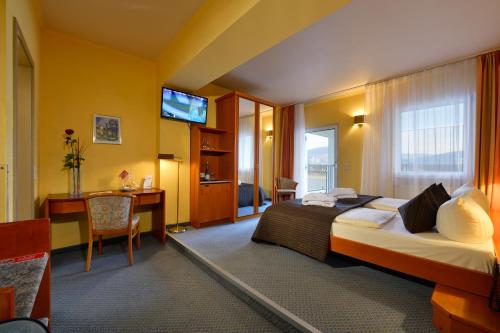 a hotel room with a bed and a desk at Rheinhotel Vier Jahreszeiten Bad Breisig in Bad Breisig