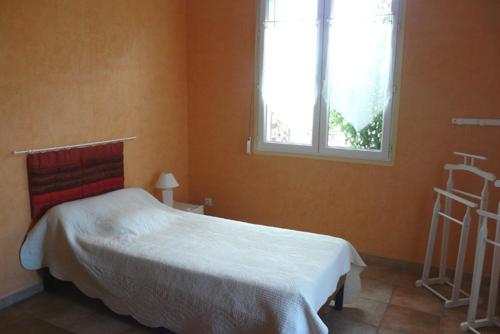 a bedroom with a white bed and a window at Le Cardonnet in Pont-Saint-Pierre