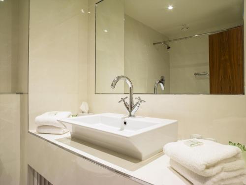 een witte badkamer met een wastafel en een spiegel bij Ballyroe Heights Hotel in Tralee