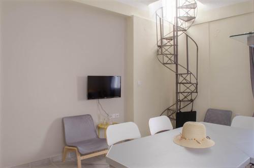 Habitación con mesa, sillas y TV. en city apartment, en Ermoupoli