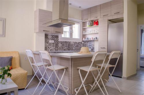 una cocina con encimera con sillas y una isla en city apartment, en Ermoupoli
