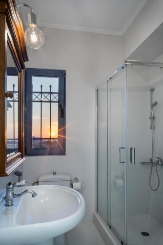 a bathroom with a sink and a glass shower at Alexander villa in Perdika