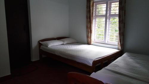 a small room with two beds and a window at StaySimple Spicefarm in Somvārpet