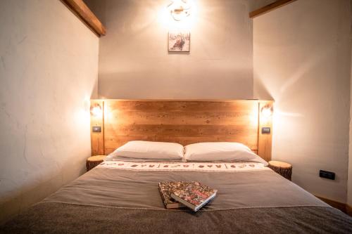 a bed with a wooden headboard in a bedroom at VillAmour Boutique Hotel & SPA in La Salle
