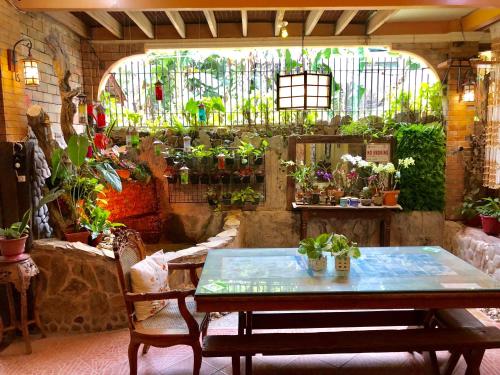 a room with a table and a lot of plants at Balai Tinay Guesthouse in Legazpi