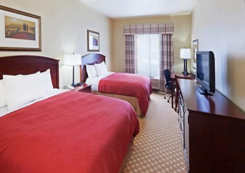 a hotel room with two beds and a flat screen tv at Country Inn & Suites by Radisson, Tulsa, OK in Tulsa