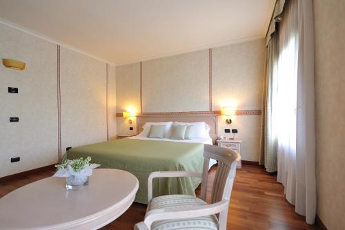 pokój hotelowy z łóżkiem i stołem w obiekcie Hotel Roxy Plaza w mieście Soave