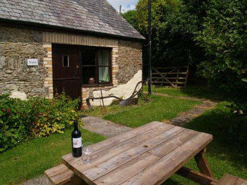 MertonにあるStable Cottageの木製のベンチに座るワイン1本