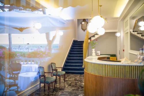 カオルレにあるHotel Le Lampareのテーブルと椅子、階段のあるレストラン