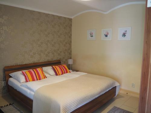 a bedroom with a large bed with colorful pillows at Penzion Pohoda in Lednice