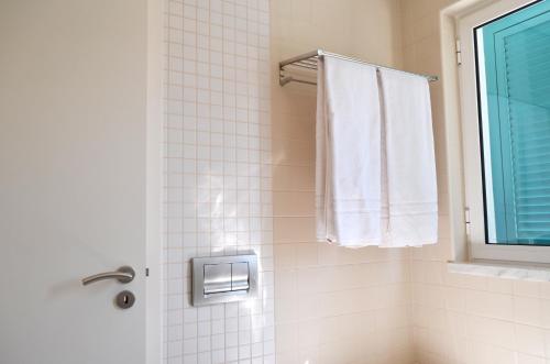 a bathroom with a shower with a window and a towel at Townhouse Prainha Beach in Alvor