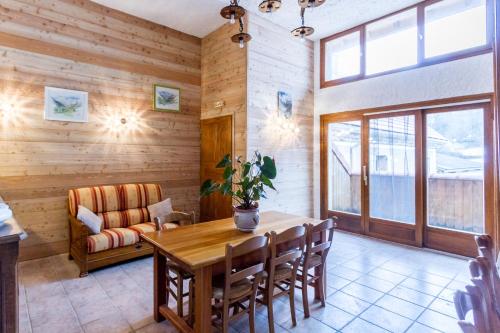 a dining room with a table and a couch at Chambres d'hotes Les Clarines in Saint-Jacques-en-Valgodemard