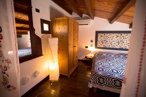 カステッランマーレ・デル・ゴルフォにあるAntiche scaleのベッドルーム(ベッド1台、鏡、ランプ付)