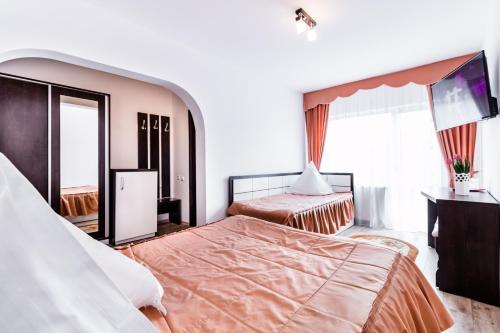 a hotel room with two beds and a television at Pensiunea Maria in Durau