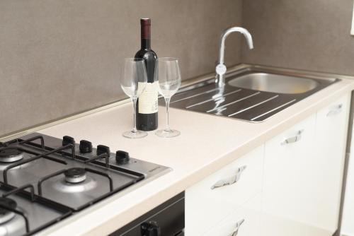 a kitchen with a stove and two glasses of wine at Apartment Ćukušić in Split