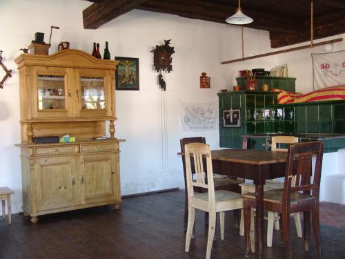 ein Esszimmer mit einem Tisch und einem Holzschrank in der Unterkunft Penzion Olesnice in Zlatá Olešnice