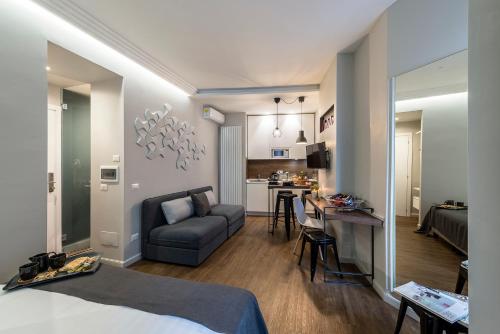 a room with a bed and a couch and a kitchen at Z-ArchSuites in Rome