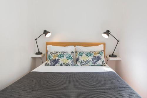 een slaapkamer met een bed met twee lampen erop bij Bica Patio 3BDR Duplex by LovelyStay in Lissabon