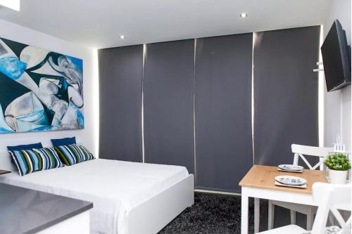 1 dormitorio con cama blanca y mesa en HomeCity, en Coímbra