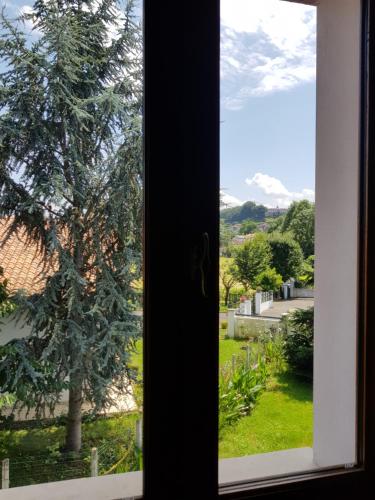 une fenêtre avec vue sur un arbre dans l'établissement Maison Bakea, à Saint-Jean-Pied-de-Port