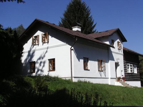 una casa bianca con finestre in cima a una collina di Penzion Olesnice a Zlatá Olešnice