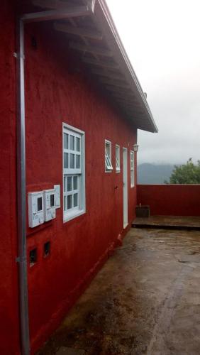 un edificio rosso con finestre bianche sul lato di Suite 195 Lavras Novas a Ouro Preto