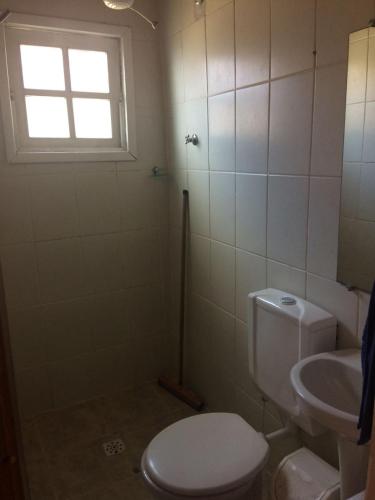 a bathroom with a toilet and a sink and a window at Suite 195 Lavras Novas in Ouro Preto