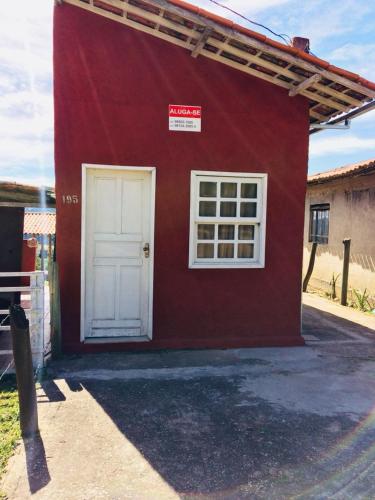 un edificio rosso con una porta bianca e una finestra di Suite 195 Lavras Novas a Ouro Preto