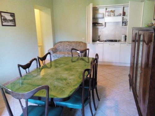 a dining room with a table and chairs and a kitchen at Bed and Breakfast Casale Nardone in Atina