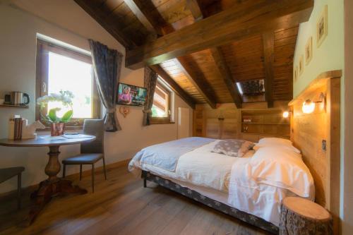 a bedroom with a bed and a table and a window at VillAmour Boutique Hotel & SPA in La Salle