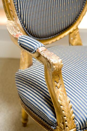a gold chair with a blue and white striped seat at Bourgogne Suite Maastricht in Maastricht