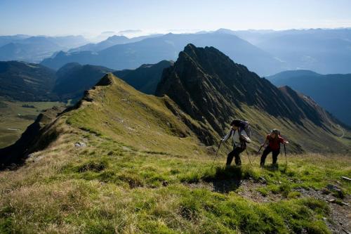 two people walking up a hill on a mountain at Central Hotel & Apart mit Landhaus Central in Fügen