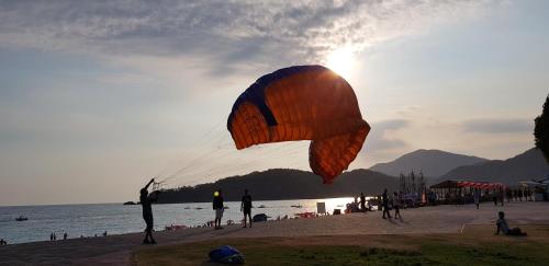 a person flying a large kite on a beach at İlkiz Beach Hotel in Oludeniz