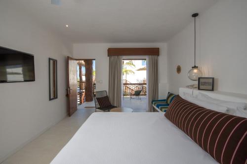 a living room with a bed and a view of a patio at Villas HM Palapas del Mar in Holbox Island