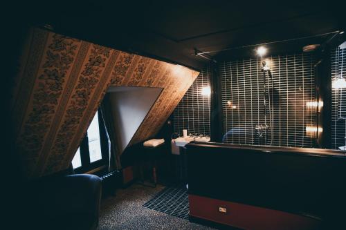 ein Badezimmer mit einer Badewanne, einem Waschbecken und einem Spiegel in der Unterkunft La Mondaine in Paris