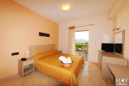 a bedroom with a bed and a flat screen tv at Hotel Marilen in Alinda