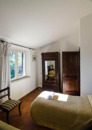 a bedroom with a bed and a chair and a mirror at Agriturismo Il Casaletto in Montefranco