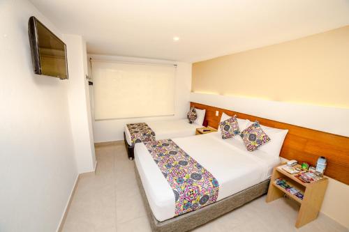 Una cama o camas en una habitación de Hotel Portobahia Santa Marta Rodadero