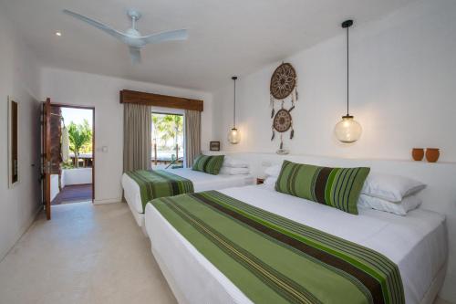 a bedroom with two beds and a window at Villas HM Palapas del Mar in Holbox Island