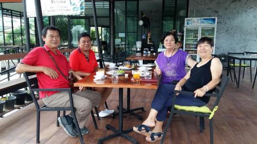 a group of people sitting at a table in a restaurant at Banana Resort Sadao in Sadao