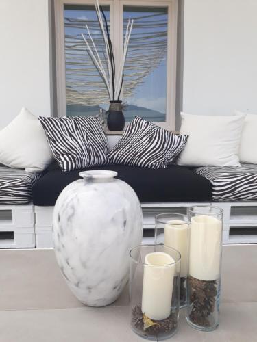 a vase and three candles on a table with a couch at SaMeCà in Tione di Trento
