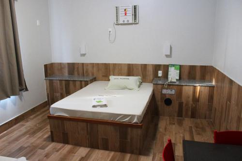 Habitación hospitalaria con cama en una habitación de madera en Hotel Palmeiras Ltda en Duque de Caxias