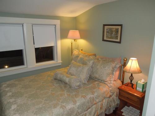 a bedroom with a bed and two windows at Wildcat Inn and Tavern in Jackson