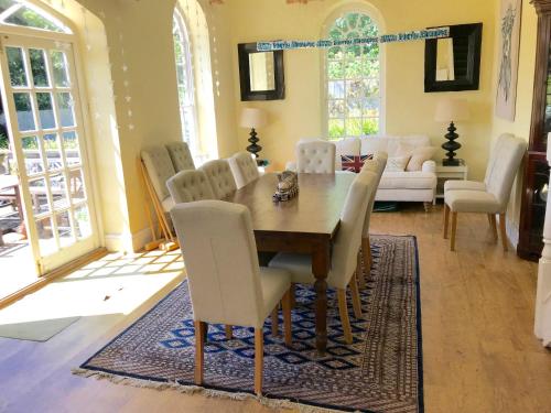 a dining room with a wooden table and white chairs at The Old Rectory,Nr Silverstone in Towcester
