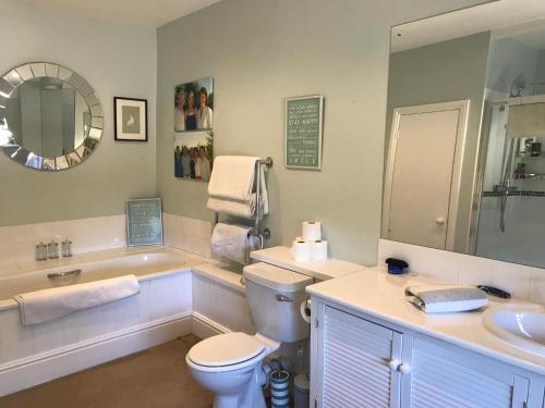 a bathroom with a toilet and a sink and a tub at The Old Rectory,Nr Silverstone in Towcester